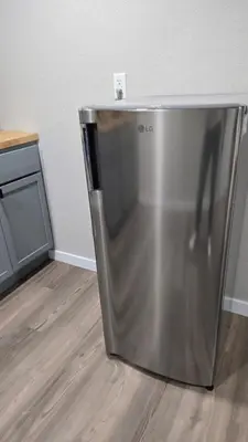 a stainless steel refrigerator sitting in a room at Alanas house in Denver