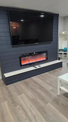 a fireplace with a tv on a wall at Alanas house in Denver