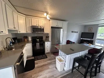 a kitchen with white cabinets and a black refrigerator at Dillon Valley Mountain Escape in Dillon