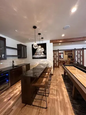 a kitchen with wooden floors and counters and tables at Serenity at Sherwood - Mid Term Rental in Breckenridge