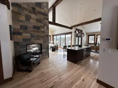 a living room with a stone wall and a fireplace at Serenity at Sherwood - Mid Term Rental in Breckenridge