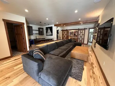 a living room with a large couch and a kitchen at Serenity at Sherwood - Mid Term Rental in Breckenridge