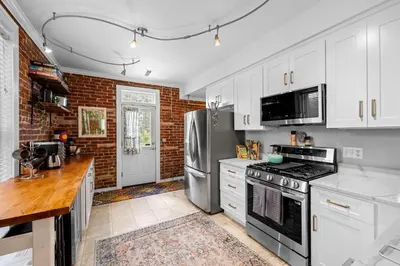 a kitchen with white cabinets and a stainless steel refrigerator at 1438 Franklin Unit 210 in Denver