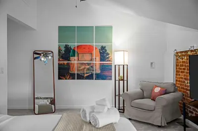 a room with a bed and a chair and a painting at 1438 Franklin Unit 210 in Denver