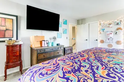 a bedroom with a bed and a flat screen tv at 8 Mi to Dtwn Denver Groovy Pet-Friendly Condo in Denver