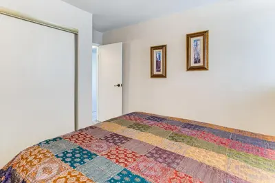 a bedroom with a bed with a colorful quilt at 8 Mi to Dtwn Denver Groovy Pet-Friendly Condo in Denver