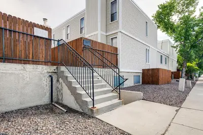 a building with a staircase next to a fence at 8 Mi to Dtwn Denver Groovy Pet-Friendly Condo in Denver