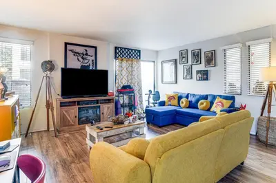 a living room with a blue couch and a tv at 8 Mi to Dtwn Denver Groovy Pet-Friendly Condo in Denver
