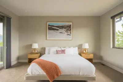 a bedroom with a white bed with two lamps and a window at Summit Solace LUXE 360 Views Hot Tub Games in Bailey