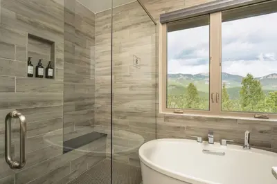 a bathroom with a tub and a window at Summit Solace LUXE 360 Views Hot Tub Games in Bailey