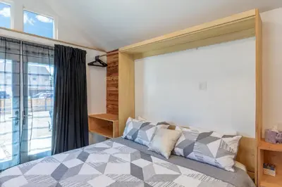 a bedroom with a bed and a large window at Modern Studio Escape in Denver in Denver