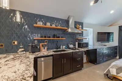 a kitchen with black cabinets and granite counter tops at Modern Studio Escape in Denver in Denver