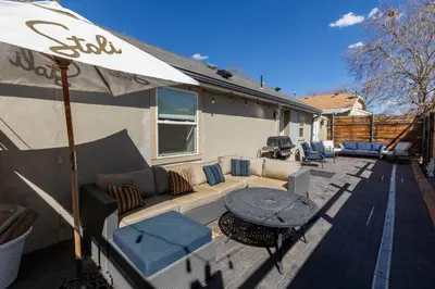 a patio with a couch and an umbrella and a table at Modern Studio Escape in Denver in Denver