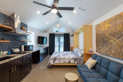 a living room with a blue couch and a bed at Modern Studio Escape in Denver in Denver