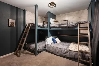 a bedroom with two bunk beds and a ladder at Pet Friendly, 4 Bedrooms Plus Game Room, Easy Walk to Lake Granby & Beacon Landing Marina in Grand Lake