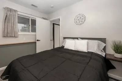 a bedroom with a black bed with a window at Pet Friendly, 4 Bedrooms Plus Game Room, Easy Walk to Lake Granby & Beacon Landing Marina in Grand Lake
