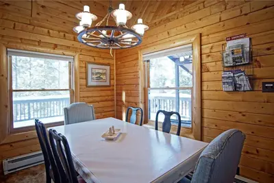 a dining room with a table and chairs and a chandelier at Large Wraparound Deck, Foosball Table, Close to Beacon Landing Marina in Grand Lake