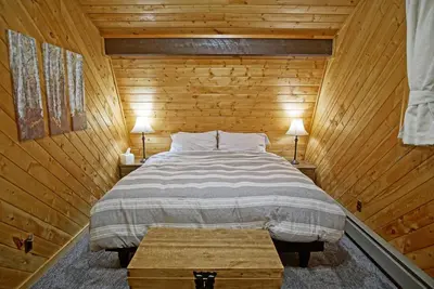 a bedroom with a bed in a wooden cabin at Large Wraparound Deck, Foosball Table, Close to Beacon Landing Marina in Grand Lake