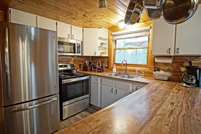 a kitchen with a stainless steel refrigerator and a sink at Large Wraparound Deck, Foosball Table, Close to Beacon Landing Marina in Grand Lake