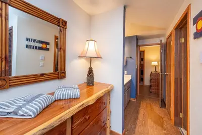 a room with a mirror and a wooden dresser at Beaver Village 1712 - Nicely Updated, 2 Queens Plus 2 Twins, Pool, Hot Tubs, Sauna in Winter Park