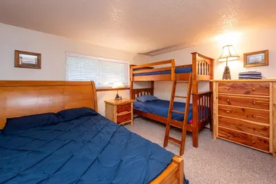 a bedroom with two bunk beds and a bed and a desk at Beaver Village 1712 - Nicely Updated, 2 Queens Plus 2 Twins, Pool, Hot Tubs, Sauna in Winter Park