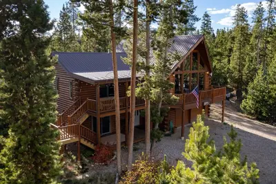 a log home in the woods with a gambrel roof at Outdoor Dining and Firepit, Pet Friendly, Breathtaking Views, High End Cabin in Grand Lake