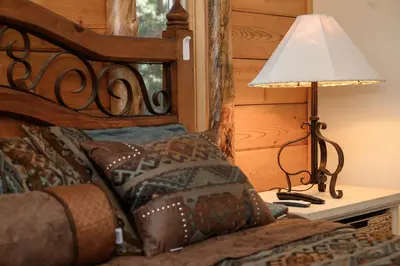a bedroom with a bed with a lamp on a table at Outdoor Dining and Firepit, Pet Friendly, Breathtaking Views, High End Cabin in Grand Lake