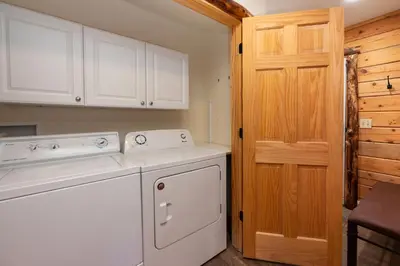 a kitchen with white appliances and a wooden door at Outdoor Dining and Firepit, Pet Friendly, Breathtaking Views, High End Cabin in Grand Lake
