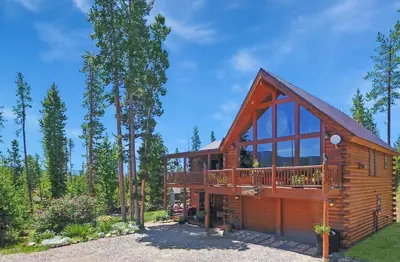 a cabin in the woods with a large deck at Outdoor Dining and Firepit, Pet Friendly, Breathtaking Views, High End Cabin in Grand Lake
