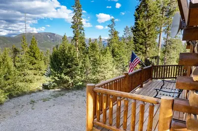 a deck with an american flag on a house at Outdoor Dining and Firepit, Pet Friendly, Breathtaking Views, High End Cabin in Grand Lake