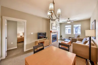 a dining room and living room with a table and a couch at Pool, Hot Tub, Ski In Ski Out, Bike Storage for Summer Guests in Winter Park