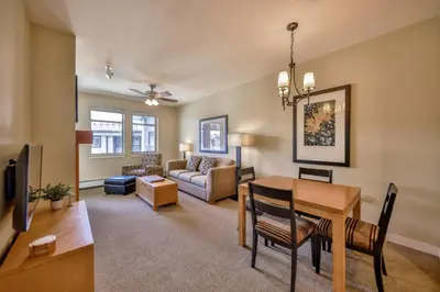 a living room with a table and a dining room at Pool, Hot Tub, Ski In Ski Out, Bike Storage for Summer Guests in Winter Park