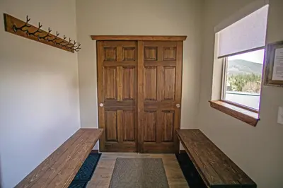 a hallway with a wooden door and a window at Pool Table, Expansive Mountain Views, New Construction, Close to Town in Grand Lake