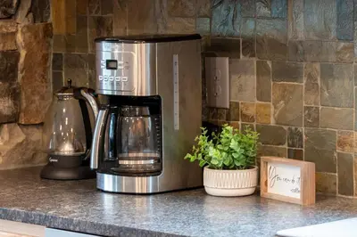 a coffee maker sitting on a counter next to a plant at Pool Table, Expansive Mountain Views, New Construction, Close to Town in Grand Lake