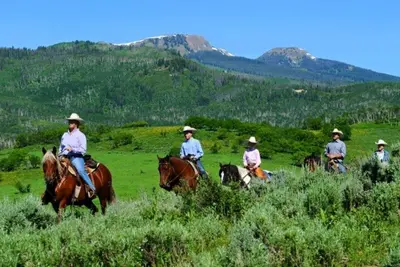 a group of people riding horses in a field at Great Deck with Gas Grill, Outdoor Firepit, 2 Blocks From Main Street in Grand Lake