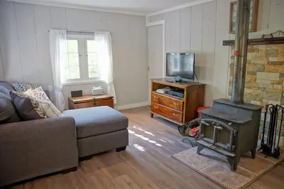 a living room with a couch and a wood stove at Great Deck with Gas Grill, Outdoor Firepit, 2 Blocks From Main Street in Grand Lake