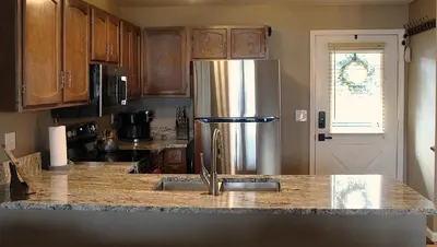 a kitchen with a stainless steel refrigerator and wooden cabinets at Lula in Grand Lake