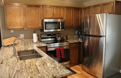 a kitchen with a stainless steel refrigerator and wooden cabinets at Lula in Grand Lake