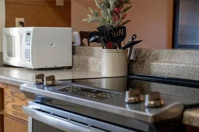 a kitchen counter with a microwave and a stove top oven at Outdoor Pool, Fireplace, Athletic Club, Covered Balcony with Views in Fraser