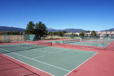 a tennis court with two tennis nets on it at Outdoor Pool, Fireplace, Athletic Club, Covered Balcony with Views in Fraser