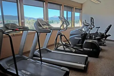 a row of exercise bikes in a gym with windows at Outdoor Pool, Fireplace, Athletic Club, Covered Balcony with Views in Fraser