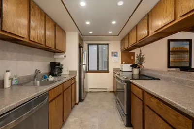 a kitchen with wooden cabinets and stainless steel appliances at Outdoor Pool, Fireplace, Athletic Club, Covered Balcony with Views in Fraser