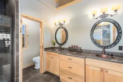 a bathroom with two sinks and two mirrors at Incredible Views, Hiking from the Property, 4 Ensuite Baths, Luxury Home in Grand Lake