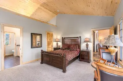 a bedroom with a bed and a wooden ceiling at Incredible Views, Hiking from the Property, 4 Ensuite Baths, Luxury Home in Grand Lake