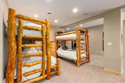 two bunk beds in a room with logs at Incredible Views, Hiking from the Property, 4 Ensuite Baths, Luxury Home in Grand Lake