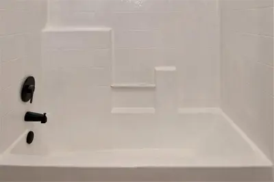 a white bath tub with a black handle at Pet Friendly - Cozy & Modern Cabin - Surrounded by Nature in Grand Lake