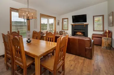 a dining room with a table and a couch and a fireplace at Pet Friendly - Cozy & Modern Cabin - Surrounded by Nature in Grand Lake