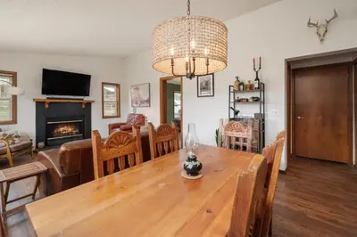 a dining room and living room with a wooden table at Pet Friendly - Cozy & Modern Cabin - Surrounded by Nature in Grand Lake