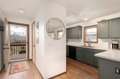 a kitchen with green cabinets and a mirror at Pet Friendly - Cozy & Modern Cabin - Surrounded by Nature in Grand Lake
