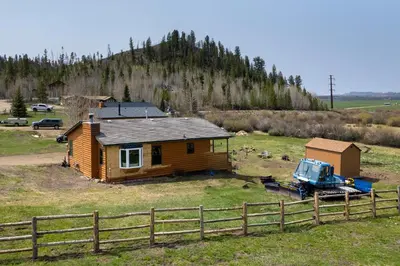 a small house and a truck in a field at Pet Friendly - Cozy & Modern Cabin - Surrounded by Nature in Grand Lake